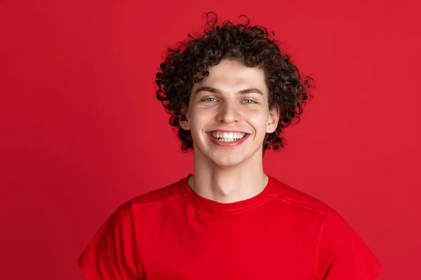 Retrato recortado de joven hombre alegre en tela casual sonriendo aislado sobre fondo rojo —  Fotos de Stock