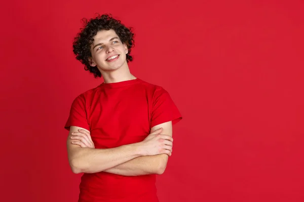 Περικοπή πορτρέτο του νεαρού άνδρα σε casual ύφασμα χαμογελώντας και κοιτάζοντας μακριά απομονωμένη πάνω από το κόκκινο φόντο — Φωτογραφία Αρχείου