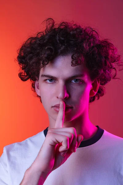 Περικοπή πορτρέτο του νεαρού άνδρα σε λευκό T-shirt με σιωπηλή έκφραση απομονώνονται πάνω κλίση ροζ πορτοκαλί φόντο σε νέον φώτα — Φωτογραφία Αρχείου