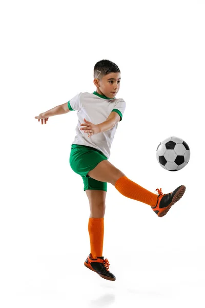 Retrato de niño, niño jugando al fútbol, entrenando aislado sobre fondo blanco. Patear la pelota en un salto —  Fotos de Stock