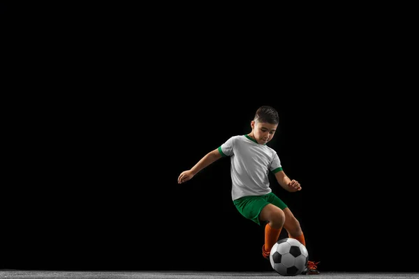 Ολο το μήκος πορτρέτο του αγοριού, του παιδιού, ποδοσφαιριστής σε ομοιόμορφη εκπαίδευση απομονώνονται σε μαύρο φόντο. Ντρίμπλα — Φωτογραφία Αρχείου
