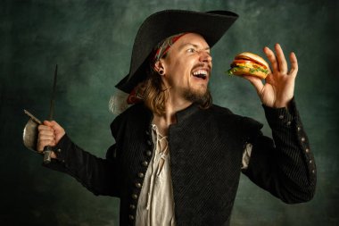 Acımasız bir adamın portresi. Karanlık arka planda izole edilmiş hamburgerli bir korsan..