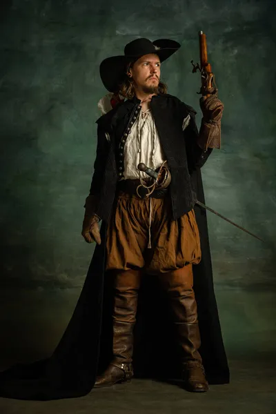 Portrait complet de l'homme brutal, pirate medeival en costume vintage avec pistolet, pistolet isolé sur fond sombre. — Photo