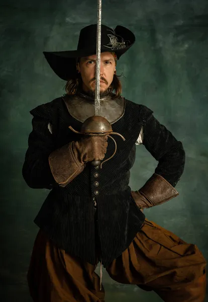 Retrato de brutal hombre horrendo, pirata medeival en traje vintage sosteniendo espada aislada sobre fondo oscuro. Swordcraft — Foto de Stock