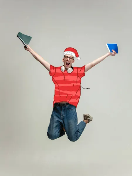 Współczesny artystyczny kolaż radosnego młodego studenta noszącego czerwony sweter i świąteczny kapelusz skaczący na szarym tle. Urlop — Zdjęcie stockowe