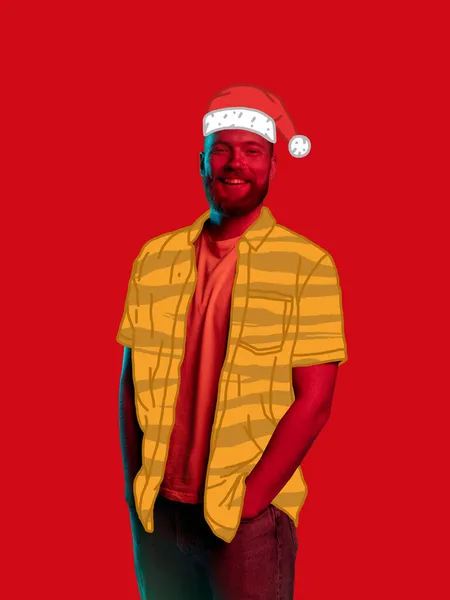 Contemporary art collage of joyful young man wearing yellow drawn shirt and holiday hat isolated over red background. Concept of winter holiday — Stock Photo, Image