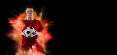 Genç adamın yaratıcı kolajı, profesyonel futbolcu eğitimi siyah arka plandaki renkli barut patlaması yüzünden izole edilmiş. El ilanı
