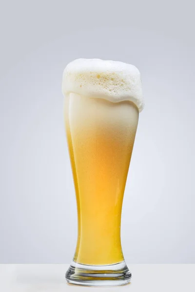Verre de bière mousseuse lager isolé sur fond gris. Notion de boissons alcoolisées — Photo