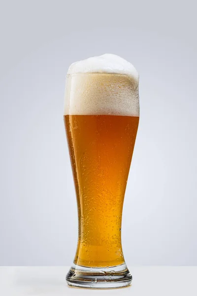 Vaso de cerveza espumosa lager aislado sobre fondo gris. Concepto de bebidas alcohólicas — Foto de Stock