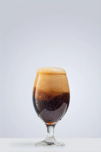 Egy pohár sötét habos sör szürke háttérrel. Az alkoholos italok fogalma, party — Stock Fotó