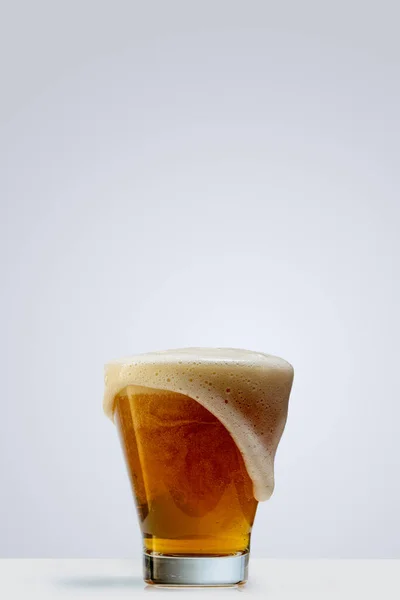 Vaso de cerveza espumosa lager aislado sobre fondo gris. Concepto de bebidas alcohólicas — Foto de Stock