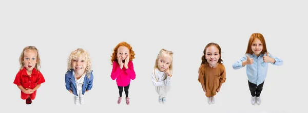 Collage van mooie vrolijke kinderen, kinderen, jongens en meisje poseren, kijken omhoog geïsoleerd over witte achtergrond — Stockfoto
