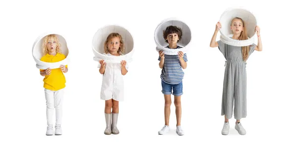 Collage of four playful joyful children, kids, boys and girl in astronaut helmets posing isolated over white background — Stock Photo, Image