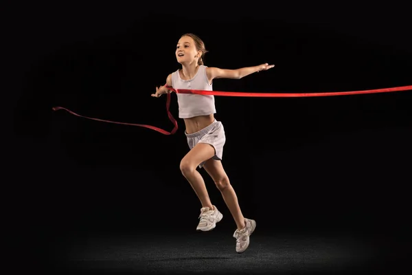 全长的少女的肖像穿过红丝带隔离在黑色的背景。跑步运动员 — 图库照片