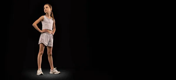 Retrato de cuerpo entero de una adolescente orgullosa, atleta profesional, corredor posando aislado sobre fondo negro. Volante —  Fotos de Stock