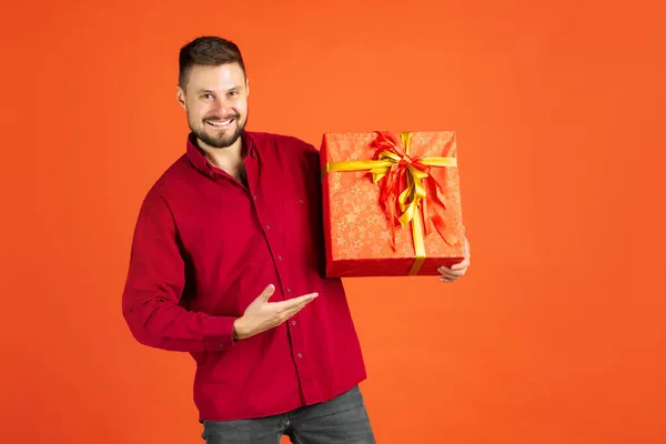 Vágott portré férfi ing gazdaság ajándék doboz vidáman pózol elszigetelt piros háttér — Stock Fotó