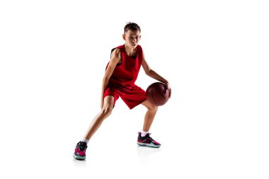 Erkek çocuk portresi, kırmızı üniformalı basketbolcu beyaz arka planda izole edilmiş. Top sürüyorum.