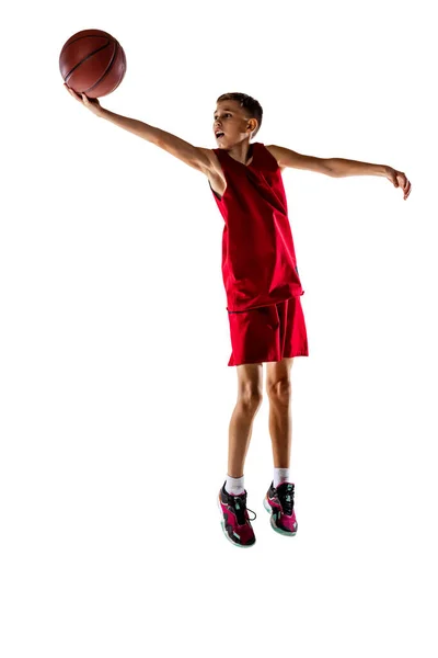 Full-length portrait of boy, basketball player training, throwing ball into the basket isolated over white background. Winning goal — Stock Photo, Image