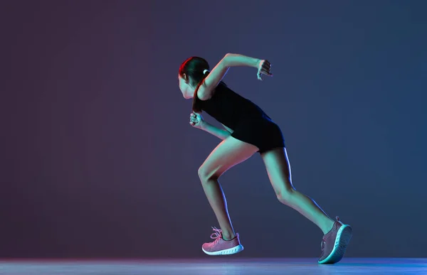 프로 운동 선수의 초상화, 네온의 푸른 보라색 배경 위에서 분리 된 달리기 훈련. 속도와 동기 — 스톡 사진