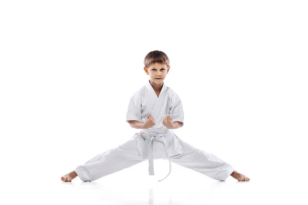 Teljes hosszúságú portré kis sportolóról, fiú edzés harcművészetek elszigetelt fehér háttér — Stock Fotó