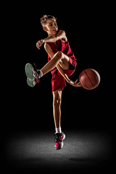 Retrato completo de menino, adolescente, jogador de basquete profissional em uniforme vermelho dando passagem isolada sobre fundo branco — Fotografia de Stock