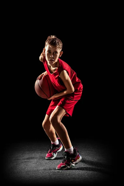 Portrait of concentrated basketball team player, sportsman training isolated over black background — Stock Photo, Image