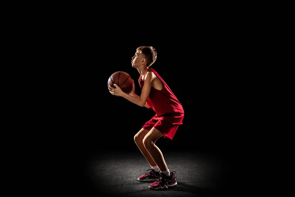 Ολο το μήκος πορτρέτο του έφηβου αγοριού, παίζει, προπόνηση μπάσκετ απομονωμένο σε μαύρο φόντο. Συγκέντρωση — Φωτογραφία Αρχείου