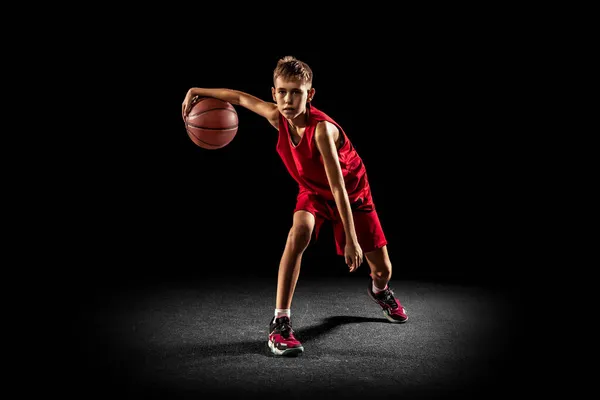 Genç bir çocuğun tam boy portresi, hareket halindeki profesyonel bir oyuncu, siyah arka planda izole edilmiş bir eğitim. — Stok fotoğraf
