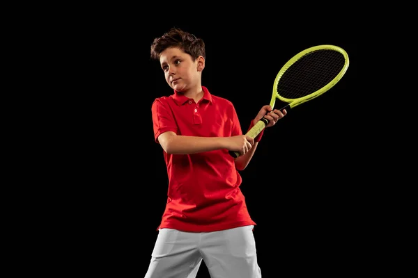 Retrato recortado de niño, jugador de tenis en movimiento, entrenamiento aislado sobre fondo negro. Equipo juego — Foto de Stock
