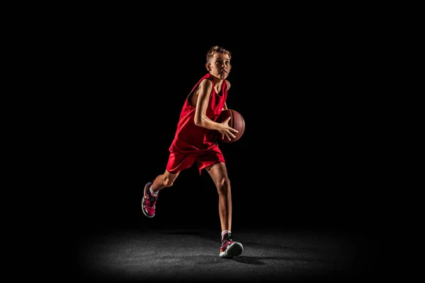 Full-length portrait of teen boy, basketball player in motion, training, running with ball isolated over black background. Goal scoring — Stock Photo, Image