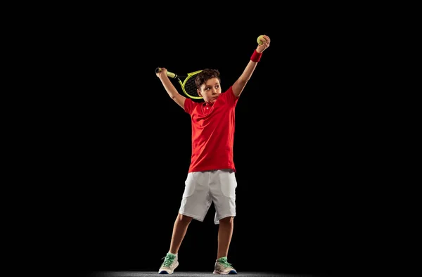 少年の完全な長さの肖像画,運動中のテニス選手,黒の背景に隔離ラケットでボールを蹴ります.ボールサービング — ストック写真