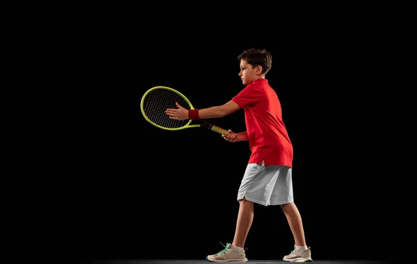 スポーツ少年の完全な長さの肖像画,テニスをプレイ,黒の背景に隔離されたトレーニング. — ストック写真