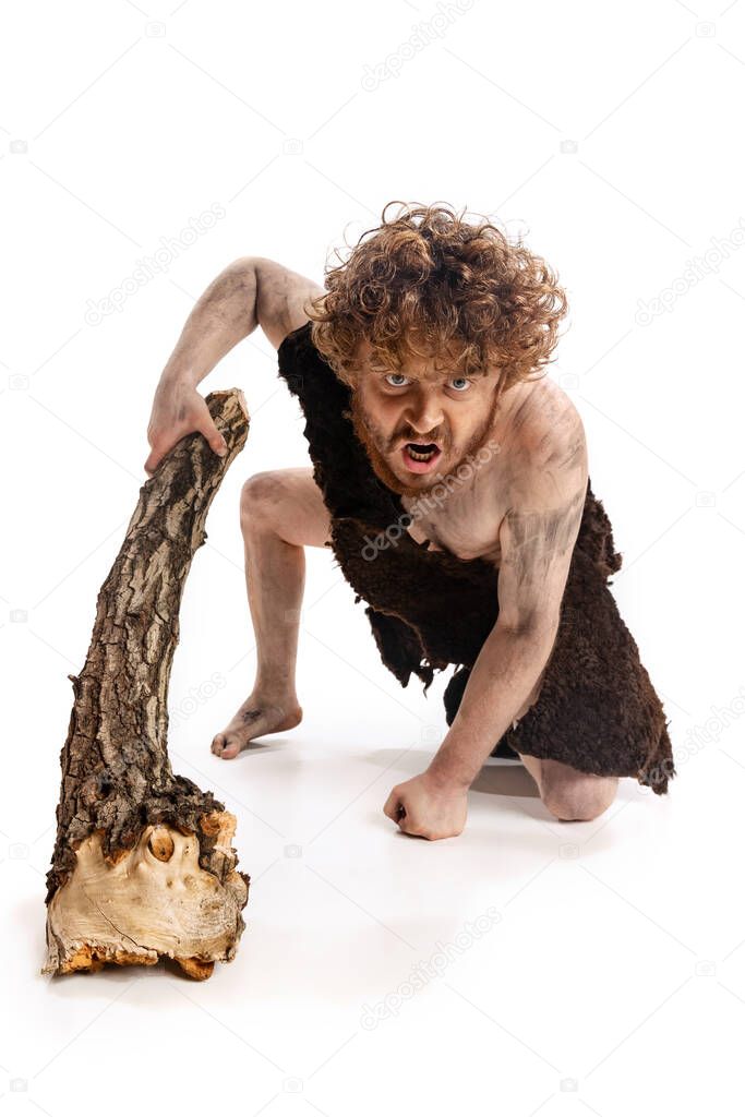 Full-length portrait of man in character of neanderthal climbing with angry expression isolated over white background
