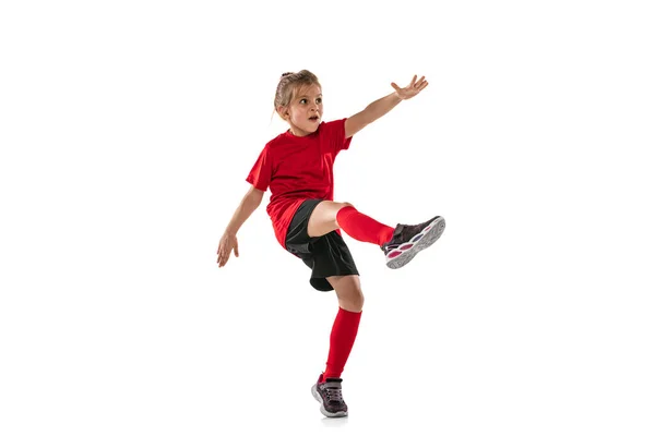 스포츠를 좋아하는 어린이, 빨간 유니폼을 입은 소녀, 흰 배경 위로 격리 된 축구를 훈련시키는 모습 — 스톡 사진