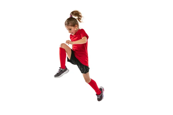 Retrato de larga duración de la niña deportiva en uniforme rojo jugando juego de equipo, entrenamiento de fútbol aislado sobre fondo blanco —  Fotos de Stock