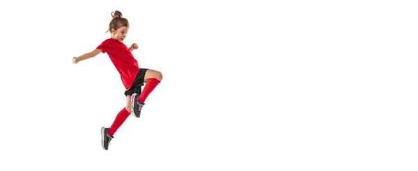 Full-length portrait of girl, child, football player in uniform training, kicking ball with knee isolated over white background. Flyer — Stock Photo, Image