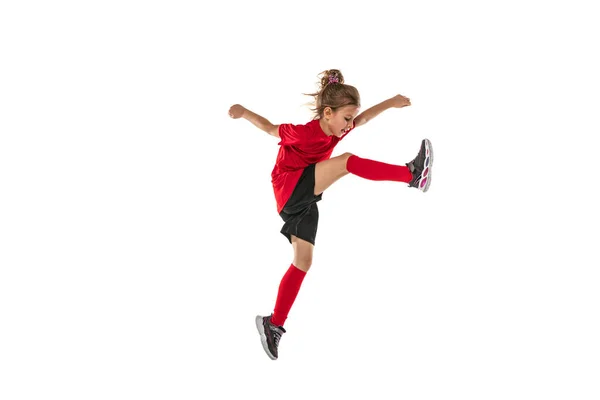 Retrato completo de niña, niño en uniforme rojo entrenando fútbol aislado sobre fondo blanco. Anotar gol en un salto —  Fotos de Stock