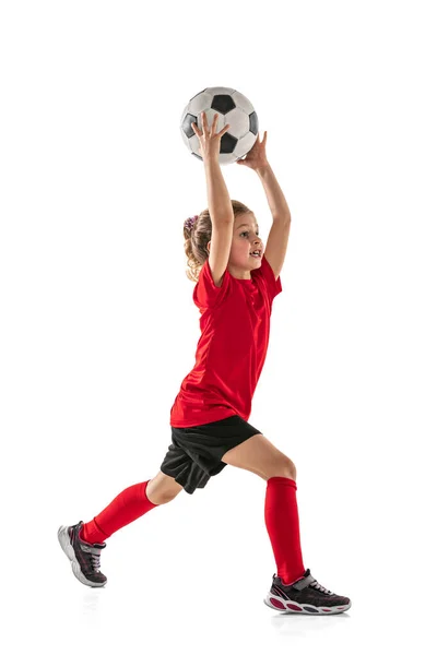 Teljes hosszúságú portré kislányról, focista tréning, dobás labda elszigetelt fehér háttér — Stock Fotó