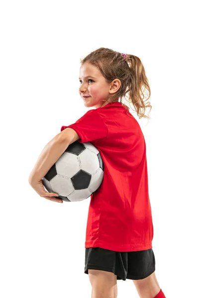 Retrato de niña, niña, en uniforme de futbolista rojo posando con pelota aislada sobre fondo blanco —  Fotos de Stock