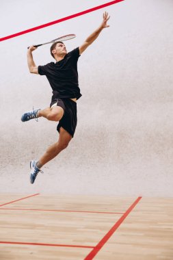 Spor stüdyosunda squash oynarken sportif erkek eğitiminin tam boy portresi.
