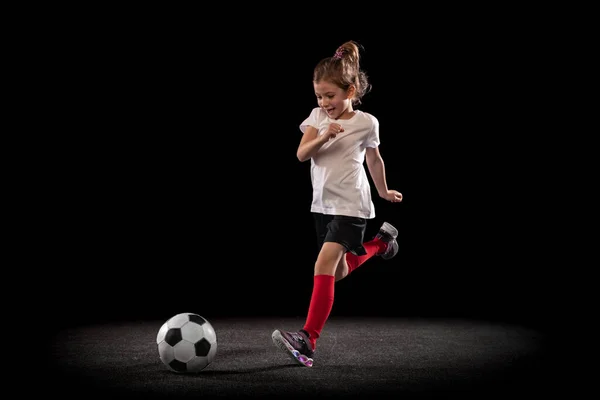 Retrato de larga duración de la chica activa en movimiento jugando fútbol aislado ver fondo negro —  Fotos de Stock