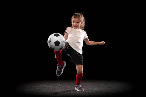 Retrato de niña, entrenamiento infantil, jugar al fútbol, patear pelota con fondo blanco negro aislado de rodilla. Goteo —  Fotos de Stock