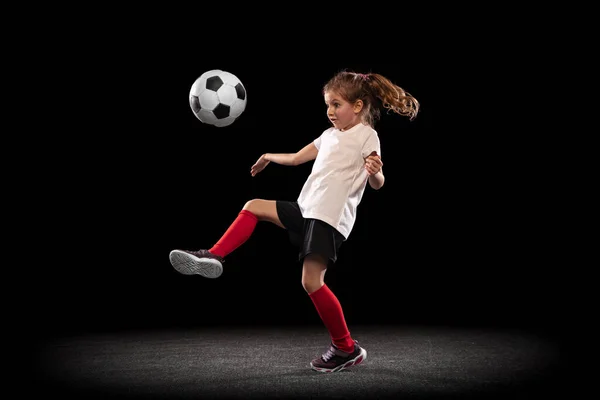 Teljes hosszúságú portré aktív lány mozgásban játszik labdarúgó elszigetelt ver fekete háttér — Stock Fotó