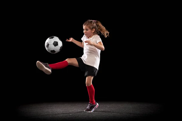 Retrato de larga duración de la chica activa en movimiento jugando fútbol aislado ver fondo negro —  Fotos de Stock