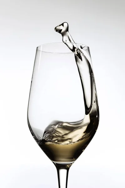 Image recadrée de verre avec vin blanc, éclaboussures d'alcool liquide isolé sur fond gris — Photo