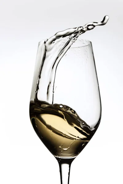 Image recadrée de verre avec vin blanc, éclaboussures d'alcool liquide isolé sur fond gris — Photo