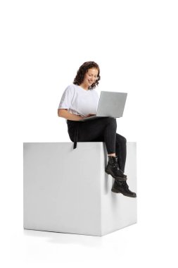 Bilgisayarda çalışan genç kızın tam boy portresi, beyaz arkaplan üzerinde izole edilmiş online konferans.