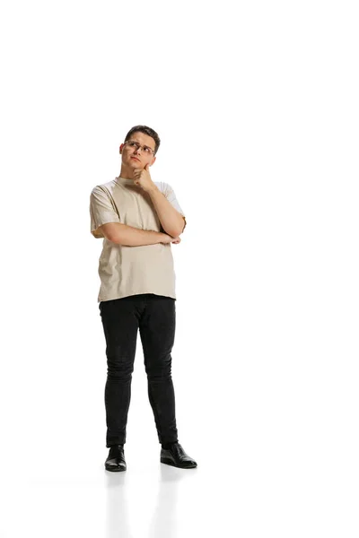 Full-length portrait of young thoughtful man generating new business ideas isolated over white background — Stockfoto