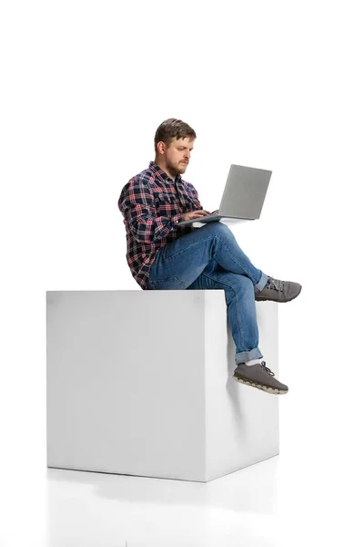 Full-length portrait of young motivated employee, man working on laptop isolated over white background — Foto Stock