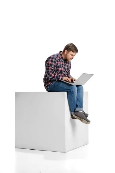 Full-length portrait of young motivated employee, man working on laptop isolated over white background — Fotografia de Stock